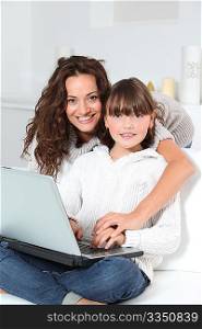 Closeup of mother and child at home with laptop computer