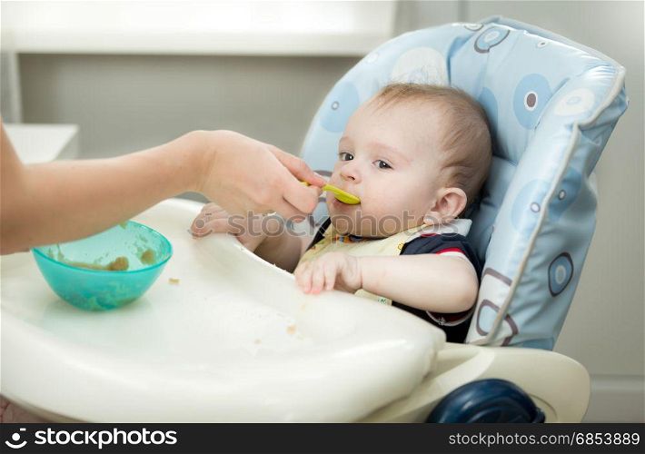 Closeup of mother giving porridge from spoon to her baby