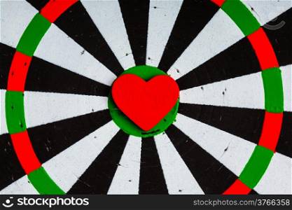 Closeup of old black and white target with red heart symbol bullseye as love background. Valentines day.