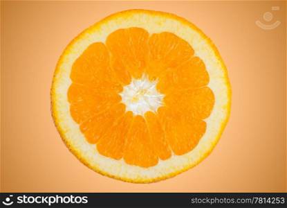 Closeup of orange slice on orange gradient background.