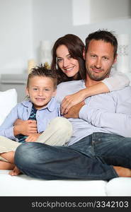 Closeup of parents and child relaxing at home on sofa