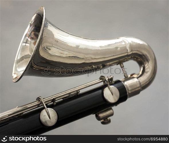 closeup of part of bass clarinet with gray background