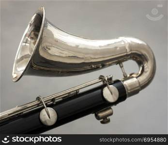 closeup of part of bass clarinet with gray background