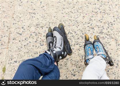 Closeup of people friends with roller skates. Woman and man relaxing outdoor.. Closeup of people friends with roller skates.