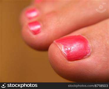 Closeup of pink nail paint, on feet, pedicure