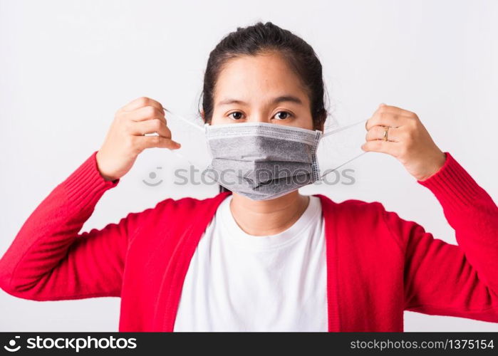 Closeup of portrait Asian adult woman wearing red shirt and face mask protective against coronavirus or COVID-19 virus showing demonstrating correct step, studio shot isolated white background