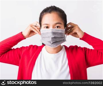 Closeup of portrait Asian adult woman wearing red shirt and face mask protective against coronavirus or COVID-19 virus showing demonstrating correct step, studio shot isolated white background