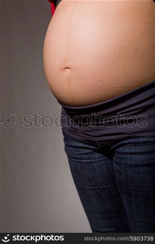 Closeup of pregnant woman at black background
