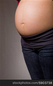 Closeup of pregnant woman at black background