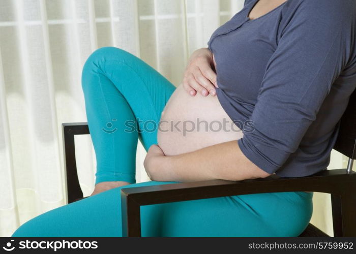 Closeup of pregnant woman at home