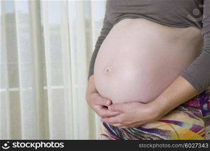 Closeup of pregnant woman, isolated on white