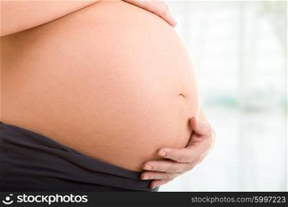 Closeup of pregnant young woman belly