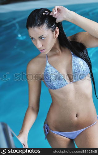 Closeup of pretty young lady have fun and posing while relaxing in the swimming pool in luxury hotel
