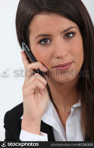 Closeup of pretty young woman in a suit on cellphone