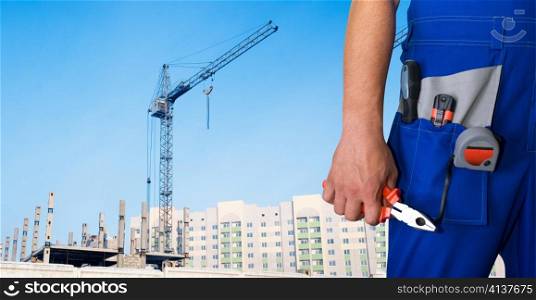Closeup of repairman with pliers on building background