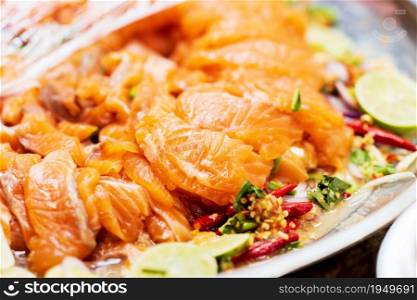 Closeup of Salmon Spicy Salad with herb recipe, thai street food market