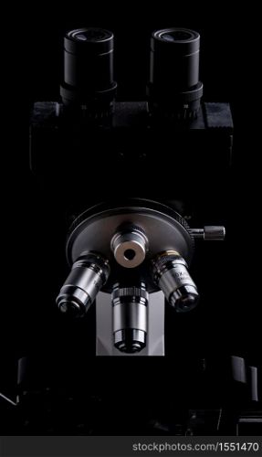 Closeup of Scientific microscope isolated on black, data analysis in the laboratory