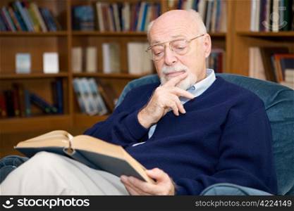 Closeup of senior man sitting in an easy chair and reading.