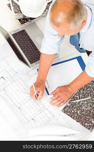 Closeup of senior man working on blueprints and construction plans