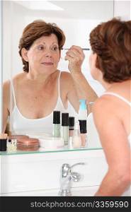 Closeup of senior woman putting makeup on