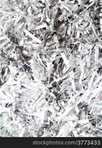 Closeup of shredded white paper with text as abstract background or texture