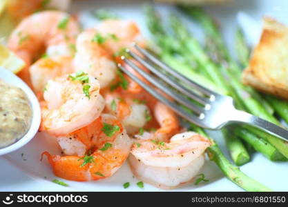 Closeup of shrimp dinner with asparagus, garlic bread and a grainy mustard and mayo sauce