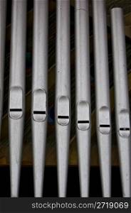closeup of silver organ pipes in a row