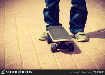 Closeup of skateboarder legs. Kid child riding skateboard outdoor. Active boy skateboarding on pavement sidewalk. Kid practicing outside. . Skateboarder legs closeup. Kid skateboarding.