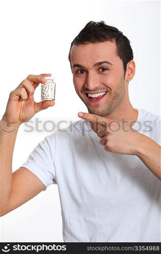 Closeup of smiling man holding bottle of pills