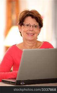 Closeup of smiling senior woman with laptop computer