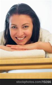 Closeup of smiling woman resting on bed at beauty spa