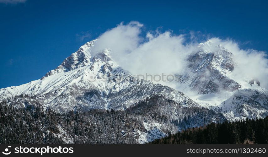 Closeup of snowy mountains and clouds in Austria