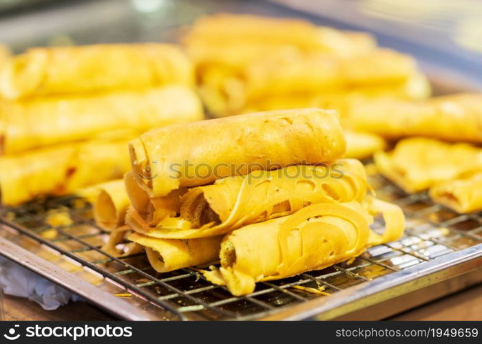 Closeup of Soft Waffle, Roll pancake stuffed, Thai dessert, background thai street food market