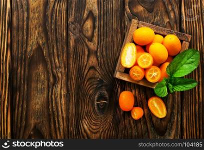 closeup of some kumquat fruits in wooden bowl
