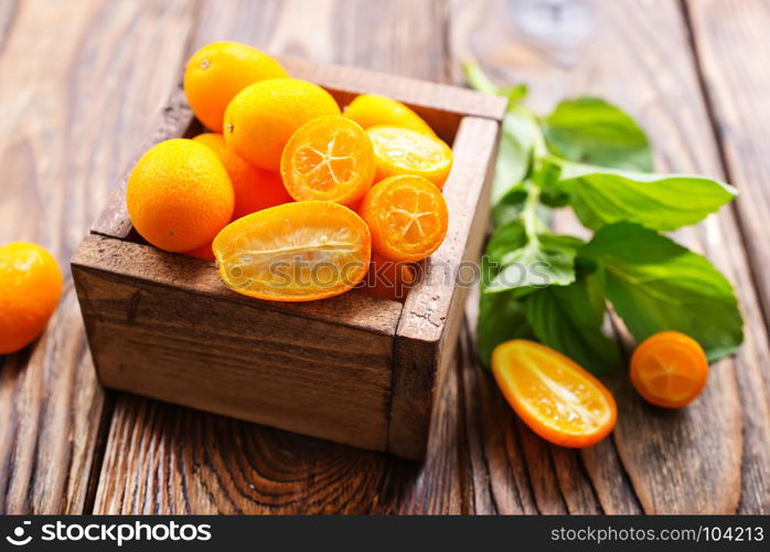 closeup of some kumquat fruits in wooden bowl