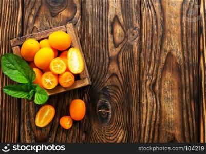 closeup of some kumquat fruits in wooden bowl