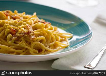 Closeup of spaghetti carbonara with egg, smoked bacon and cheese over a table. Italian spaghetti carbonara