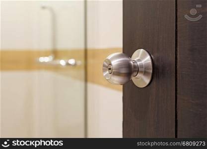 closeup of stainless doorknob on wooden door