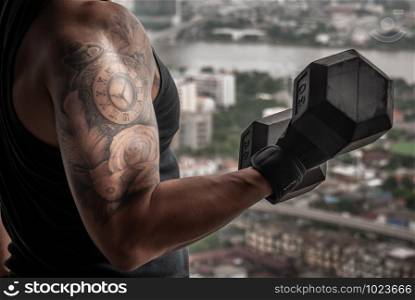 Closeup of Strong bodybuilder, power athletic man in training pumping up muscles with dumbbell in gym or fitness club.
