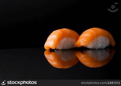 closeup of sushi with rice on black background with reflection. sushi on black background