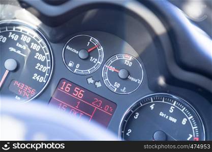 Closeup of the dashboard of a sports car, tachometer and fuel indicator