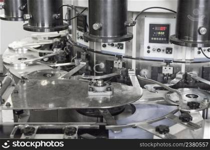 closeup of the machine produces parts for the car. equipment for the production of filters for cars