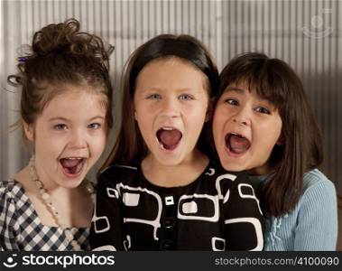 Closeup of three cute young girls screaming