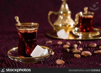 Closeup of Tunisian tea in traditional glass and pine nuts. Tunisian tea in traditional glass