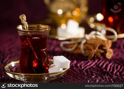 Closeup of Turkish tea in traditional glass and sugar cube. Turkish tea in traditional glass