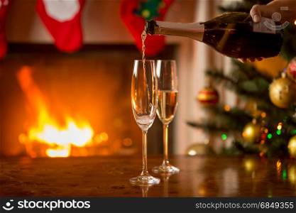 Closeup of two glasses of champagne next to the fireplace