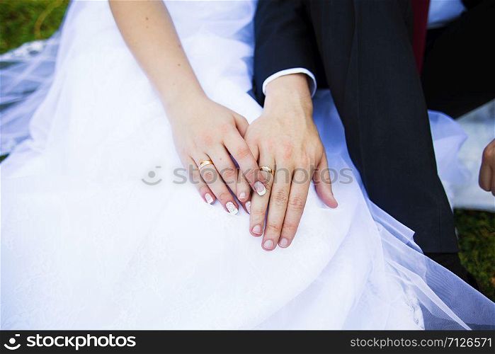 closeup of two hands of young adults with wedding rings