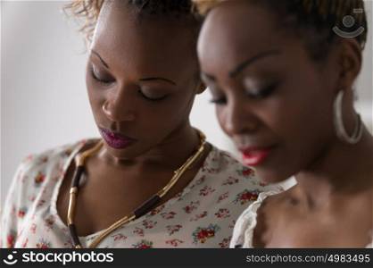 Closeup of two young african cheerful women friends together