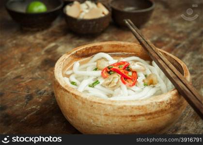 closeup of udon noodle in wood bowl on wooden floor
