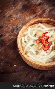 closeup of udon noodle in wood bowl on wooden floor